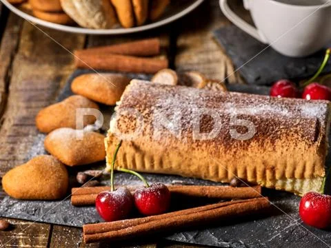 Sand cookies heart shape and rolled cake with cherry and coffee bean Stock Photos