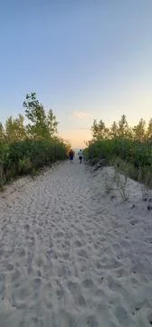 A Sand Covered Path To A Beach At Dusk Stock-Fotos