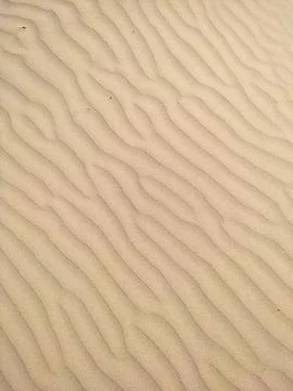 Sand in the desert with a pattern from the wind as a background Stock Photos