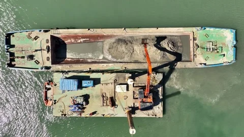 Sand dredging with digger and barge at portrush harbour northern ireland - Stock Footage 334975285