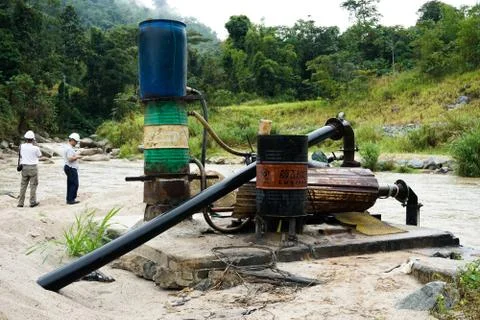 Sand dredging machine removing sand in river from river bank - Image Stock Photos