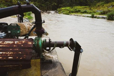 Sand dredging machine removing sand in river from river bank - Image Stock Photos