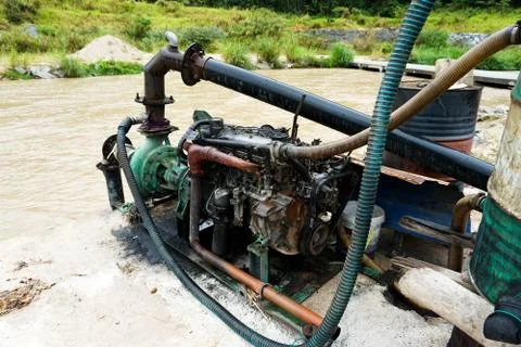 Sand dredging machine removing sand in river from river bank - Image Stock Photos