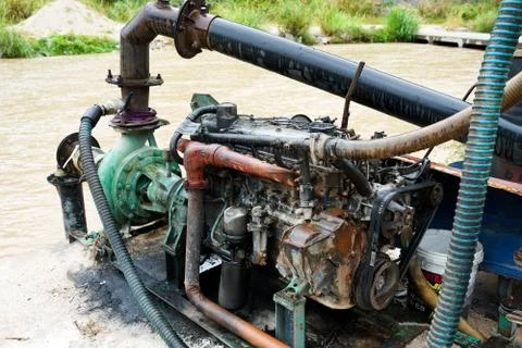 Sand dredging machine removing sand in river from river bank - Image Stock Photos