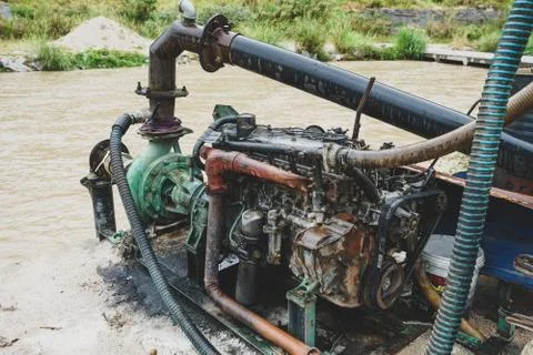 Sand dredging machine removing sand in river from river bank - Image Stock Photos