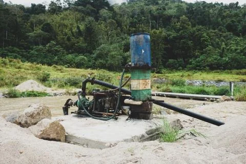 Sand dredging machine removing sand in river from river bank - Image Stock Photos