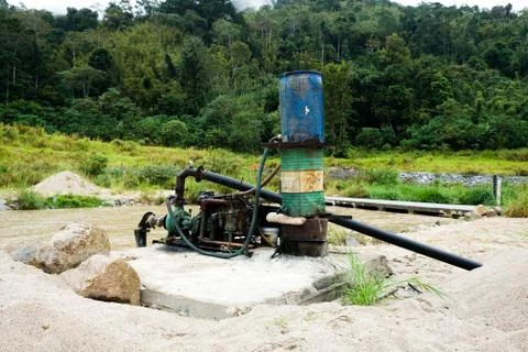 Sand dredging machine removing sand in river from river bank - Image Stock Photos
