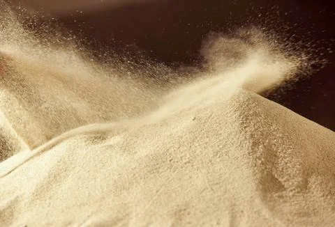 Sand dune blowing explosion, Sandy fly wave over dark background. Stock Photos