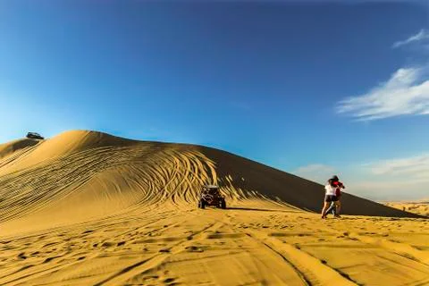 Sand dune buggy racing down the slope as tourists move aside to avoid acciden Stock Photos
