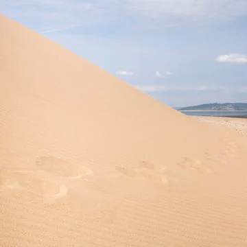 Sand dune with footsteps Stock Photos