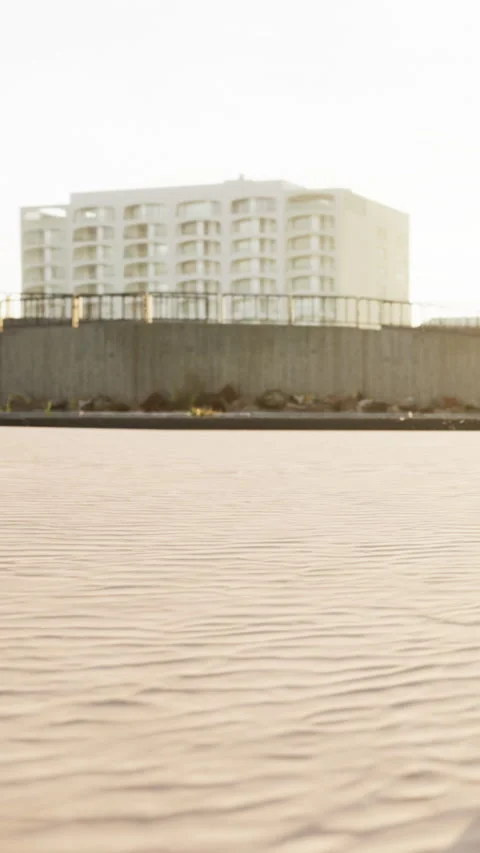 Sand dunes with buildings in the background during sunset near the shore Stock Footage 342609204