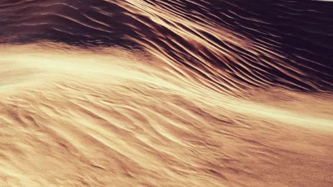 Sand dunes create patterns in a desert landscape at sunset Stock Footage 345045878