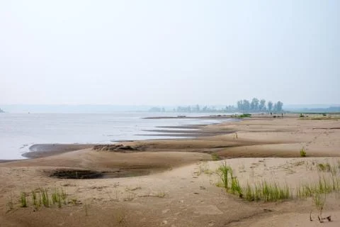 Sand dunes of a river beach at sunset Stock Photos