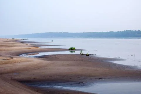 Sand dunes of a river beach at sunset Stock Photos