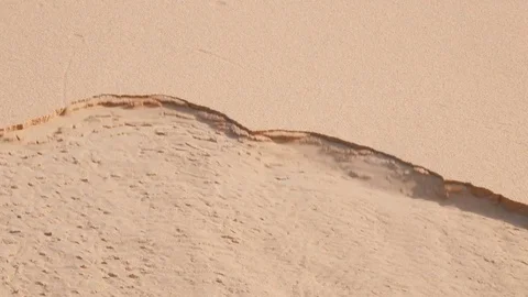 Sand eroding itself up the side of a sand dune Stock Footage 76936234