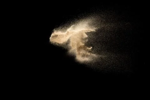 Sand explosion isolated on black background. Freeze motion of sandy dust. Stock Photos