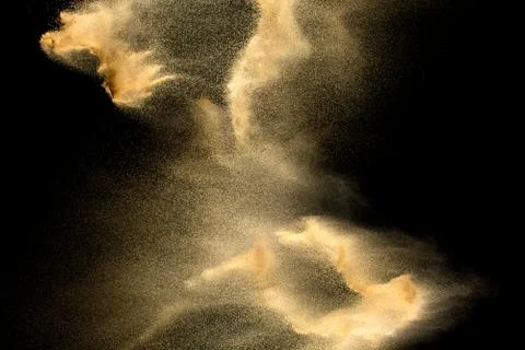 Sand explosion isolated on black background. Freeze motion of sandy dust. Stock Photos