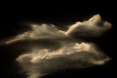 Sand explosion isolated on black background. Freeze motion of sandy dust spla Foto stock