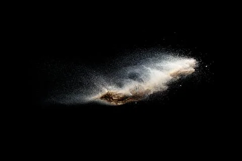 Sand explosion isolated on black background. Freeze motion of sandy dust. Stock Photos