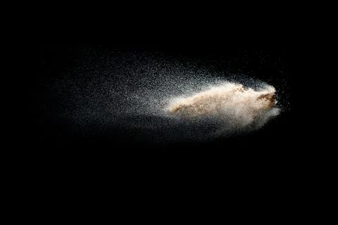 Sand explosion isolated on black background. Freeze motion of sandy dust. Stock Photos