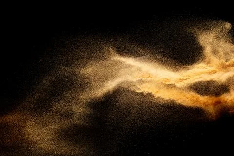 Sand explosion isolated on black background. Freeze motion of sandy dust. Stock Photos