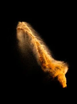 Sand explosion isolated on black background. Freeze motion of sandy dust. Stock Photos