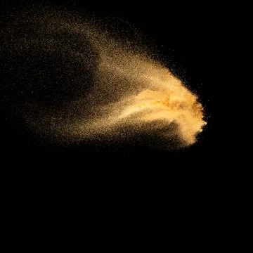 Sand explosion isolated on black background. Freeze motion of sandy dust. Stock Photos