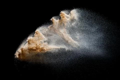 Sand explosion isolated on black background. Freeze motion of sandy dust sp.. Stock Photos