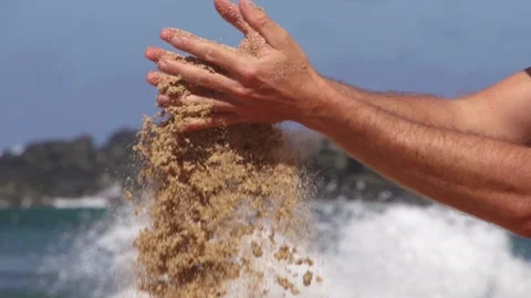 Sand falling from hands of man in super slow motion at the beach. Stock Footage 136258739