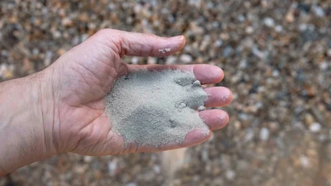 Sand falls between the fingers of a man's hand Stock Footage 129237822