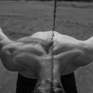 Sand falls on the man's back Stock Photos