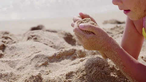 Sand flowing through the hands against blue ocean. Summer beach holiday vacation Vídeo Stock 128118347
