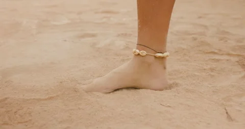 Sand foot stomp action on the beach featuring a close-up of a bare foot leaving Stock Footage 322799078