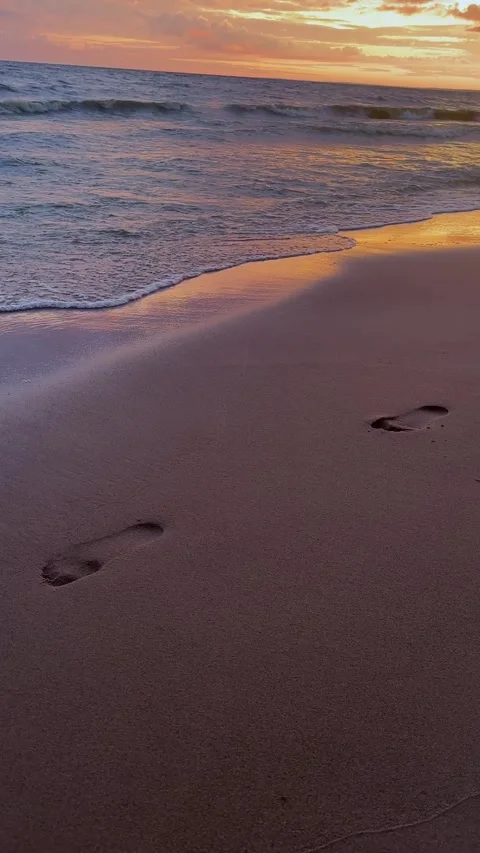 Sand footprints of bare feet on the beach at sunset. Vacation and relax concept Stock-Footage 292559599