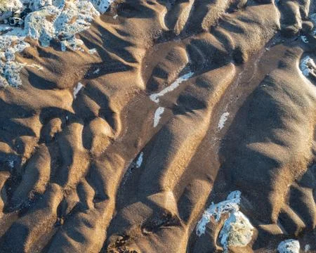 Sand formations on the beach at sunset Stock Photos