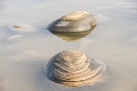 Sand forms abstract shape on the rocks as the tide goes out Stock Photos