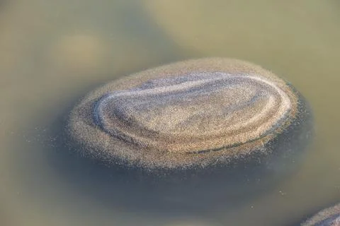 Sand forms abstract shape on the rocks as the tide goes out Stock Photos