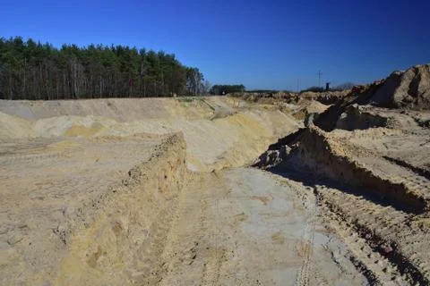 A sand mine in the sharp light of the midday sun. Stock Photos