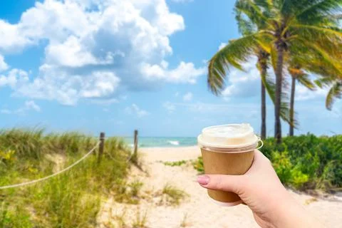 Sand Path going to the ocean in Miami Beach, Florida with Hand holding paper cup Stock Photos