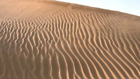 Sand patterns become more defined as evening light fades, casting soft shadows Stock Photos