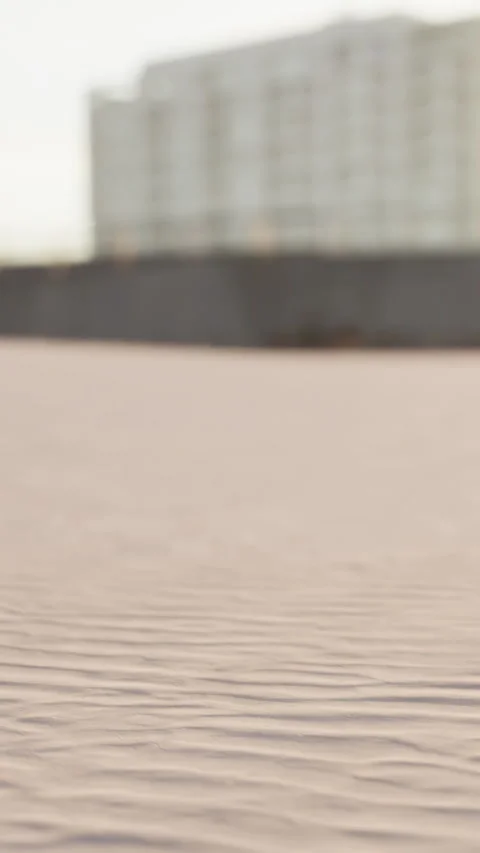 Sand patterns in a desert with buildings in the background at sunset 動画素材 338382574