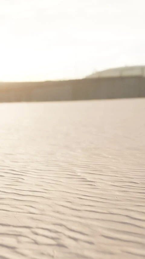 Sand patterns stretched across a beach at sunset near the ocean Stock Footage 338379756