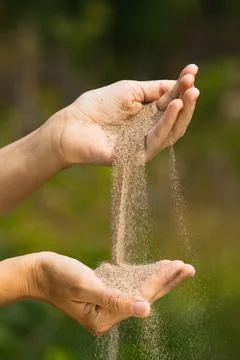 Sand pouring from one hand to another Stock Photos