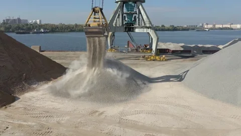 Sand pouring out of the bucket of a loading crane. Aerial view. Stock Footage 169950103