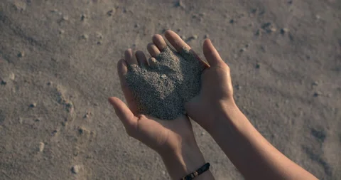 Sand pours between the fingers of the palms on a close-up Stock-Footage 133880945