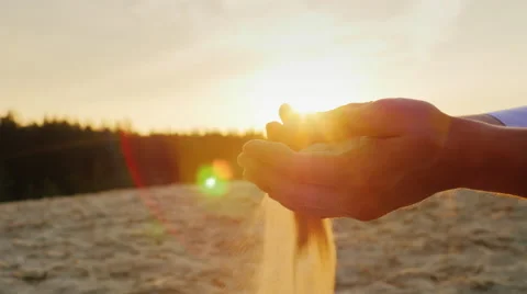 Sand pours from the man's hands at sunset. Concept: the transience of time Stock Footage 66036996