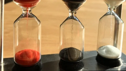 Sand pours through three hourglasses Stock Footage 95941730