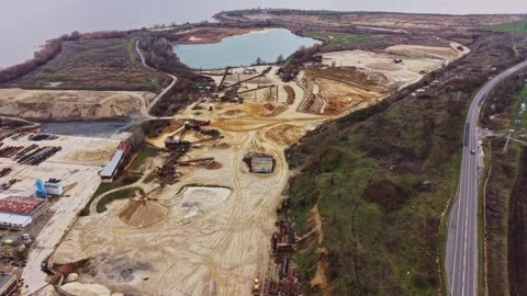 Sand quarry and extraction site near water body during cloudy day Stock Footage 337391668