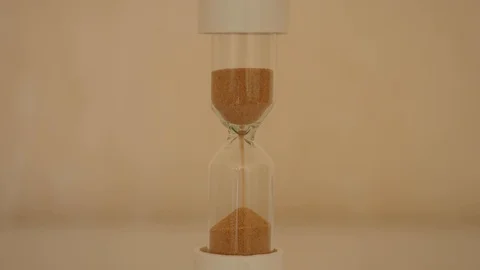 Sand running in hourglass.  Beige background Stock Footage 127839655