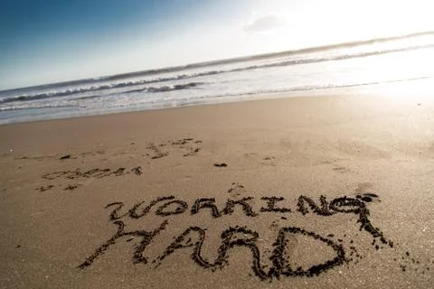 Sand script with ocean at background Stock Photos